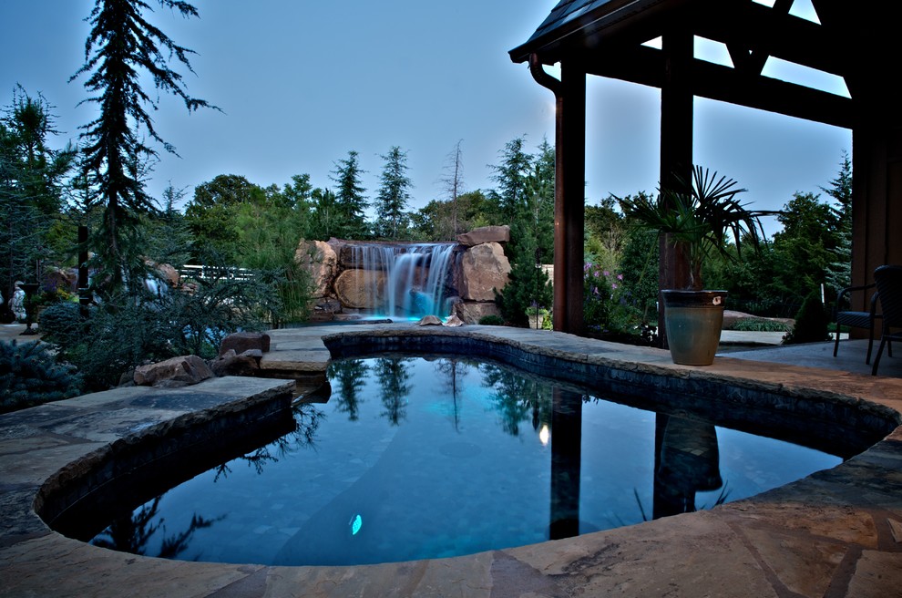 На фото: огромный естественный бассейн произвольной формы на заднем дворе в современном стиле с фонтаном