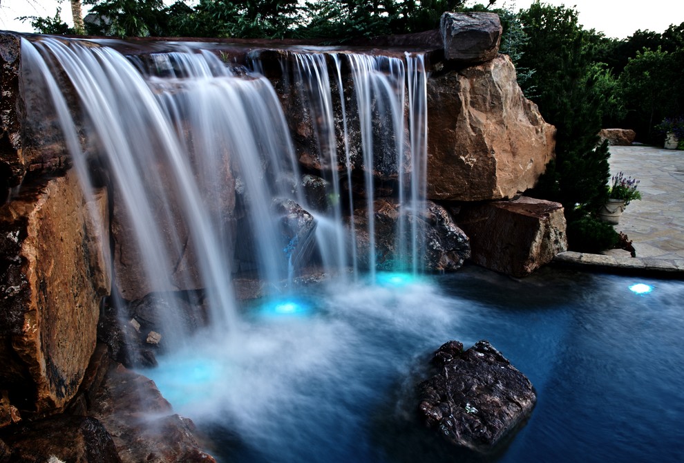Immagine di un'ampia piscina naturale mediterranea personalizzata dietro casa con una vasca idromassaggio
