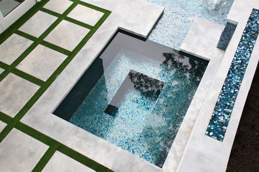 Пример оригинального дизайна: большой угловой бассейн-инфинити на заднем дворе в стиле модернизм с фонтаном и покрытием из бетонных плит