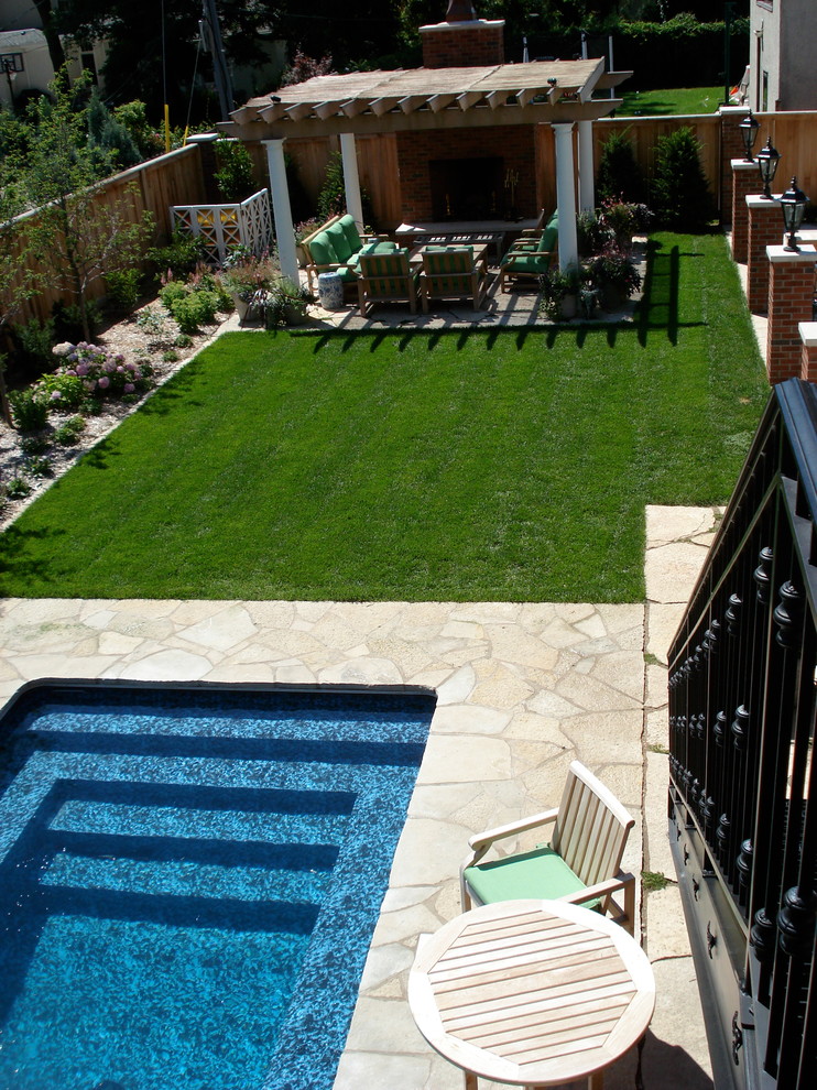 Diseño de piscina con fuente alargada tradicional grande rectangular en patio trasero con adoquines de piedra natural