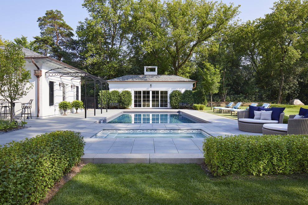 Diseño de casa de la piscina y piscina alargada tradicional grande rectangular en patio trasero con suelo de baldosas
