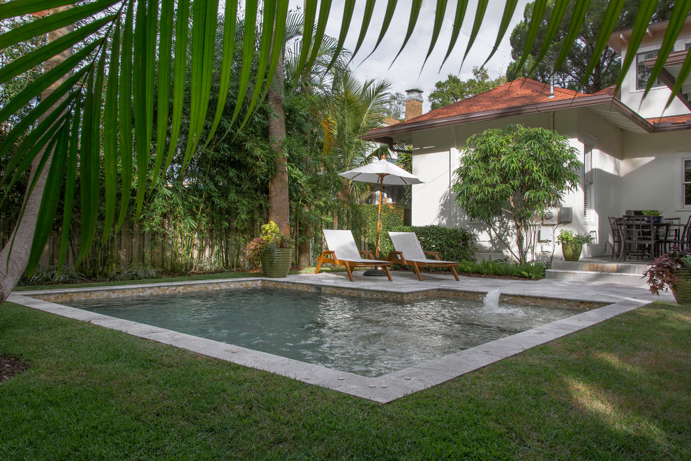 Ispirazione per una piccola piscina naturale minimalista a "L" dietro casa con una vasca idromassaggio e pavimentazioni in pietra naturale