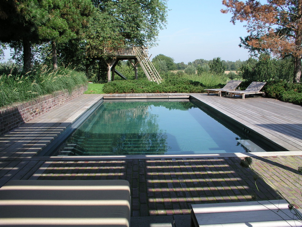Inspiration pour un grand couloir de nage rustique rectangle avec une terrasse en bois.