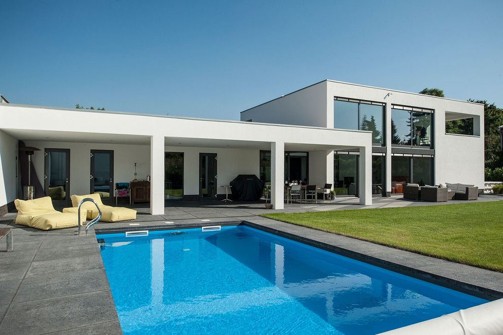 This is an example of a medium sized contemporary back rectangular swimming pool in Cologne with concrete paving.