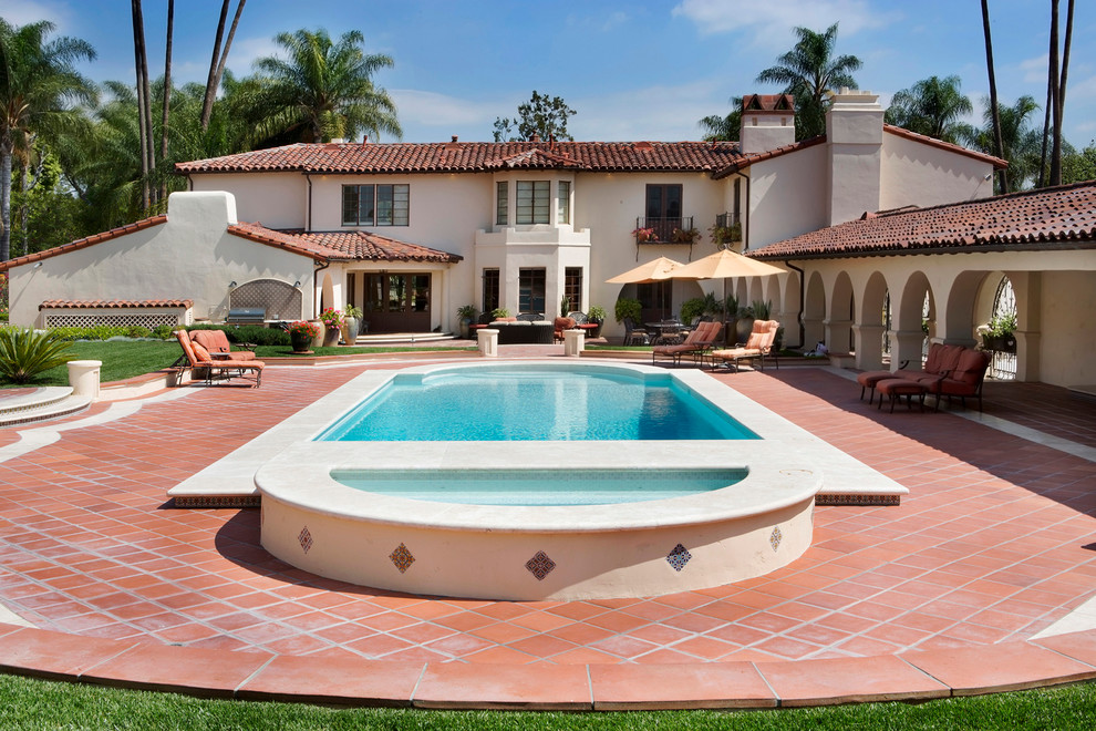 Esempio di una piscina monocorsia mediterranea personalizzata dietro casa con piastrelle