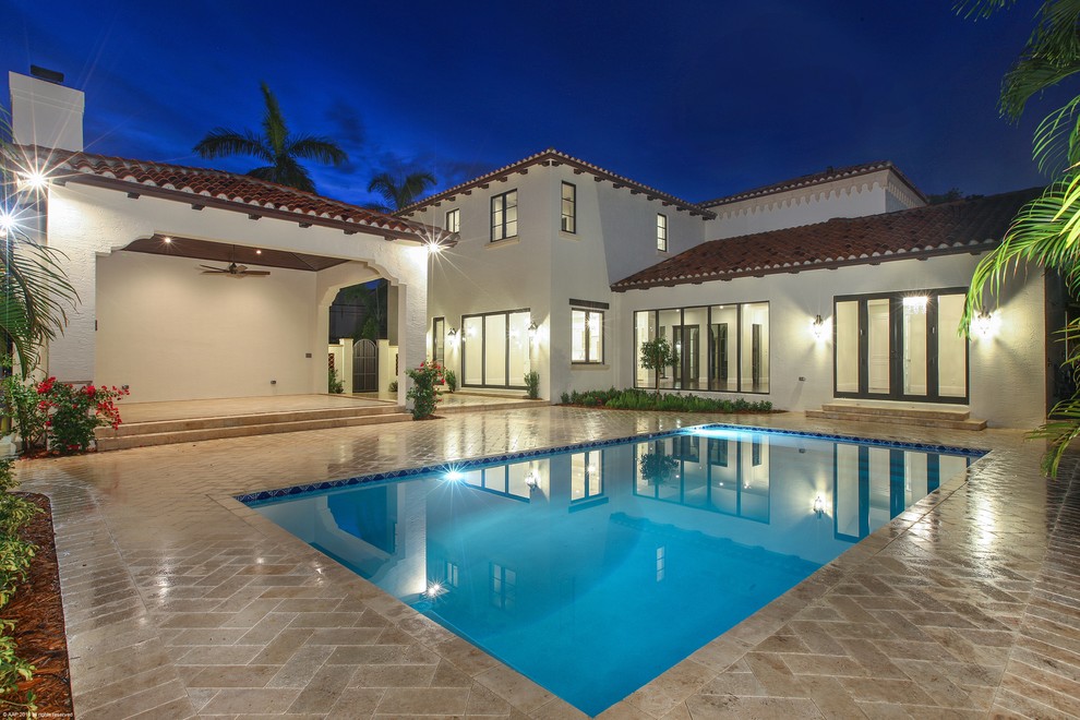 Large tuscan backyard stone and rectangular pool photo in Miami
