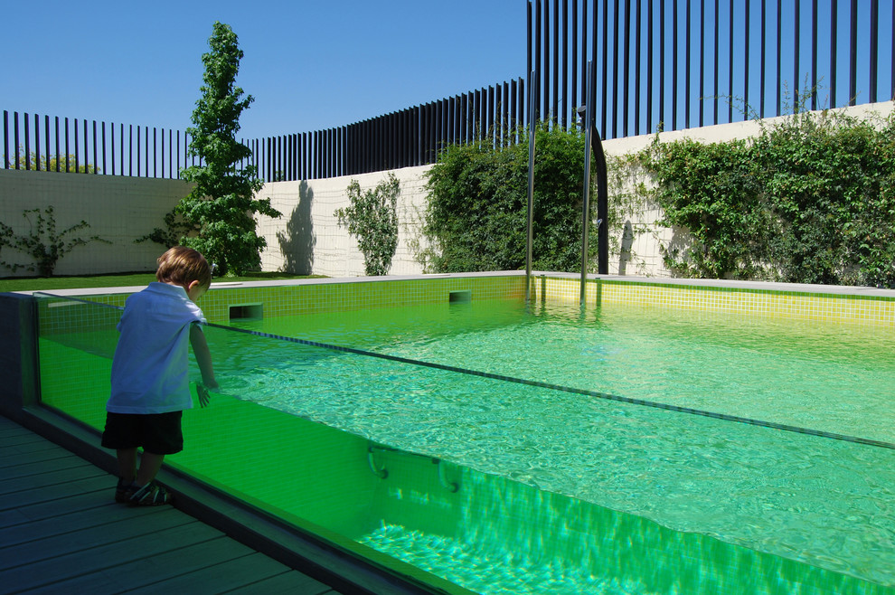 Modelo de casa de la piscina y piscina alargada bohemia en forma de L en patio con suelo de baldosas