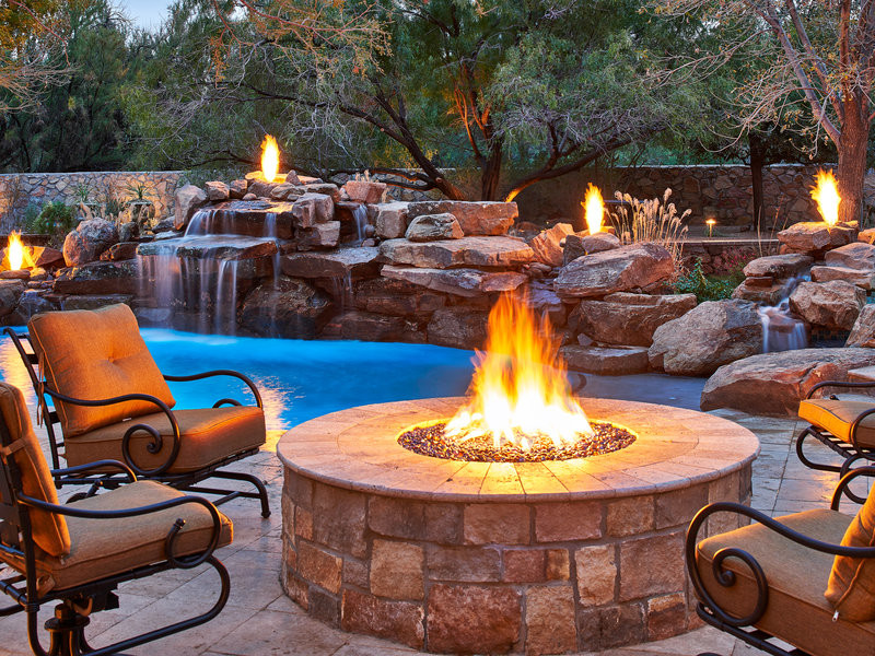 Diseño de piscina con fuente alargada de estilo americano grande a medida en patio trasero con adoquines de piedra natural