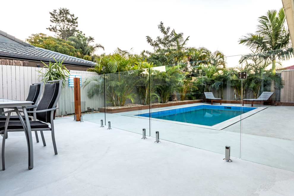 Modelo de piscina costera de tamaño medio rectangular y interior con losas de hormigón