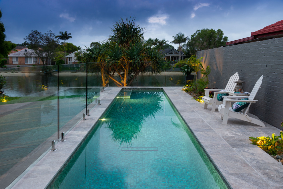 Imagen de piscina alargada contemporánea rectangular con suelo de baldosas