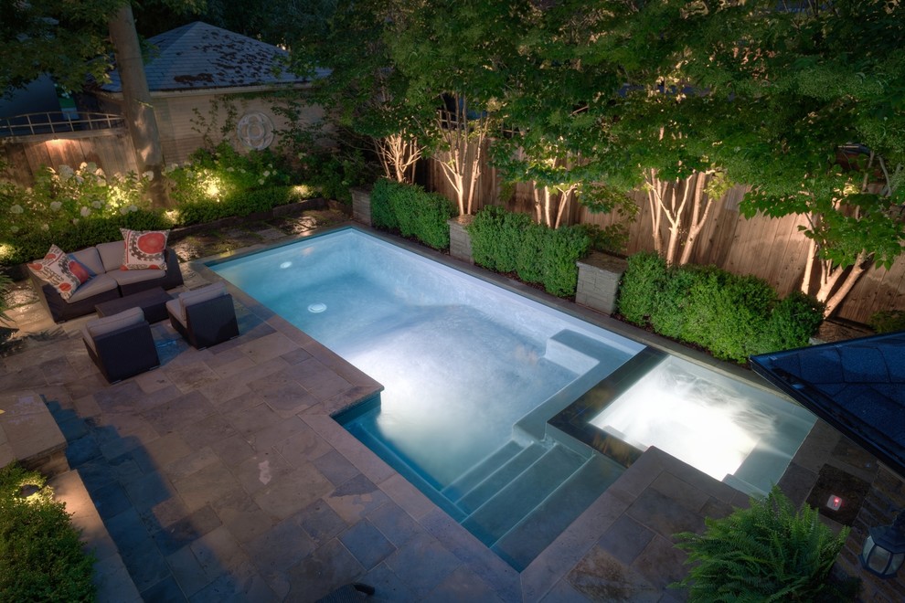 Immagine di una piccola piscina design rettangolare dietro casa con una vasca idromassaggio e pavimentazioni in pietra naturale
