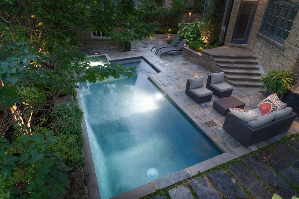Bild på en liten funkis rektangulär pool på baksidan av huset, med spabad och naturstensplattor