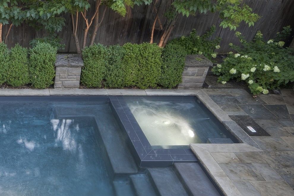 Diseño de piscinas y jacuzzis actuales pequeños rectangulares en patio trasero con adoquines de piedra natural