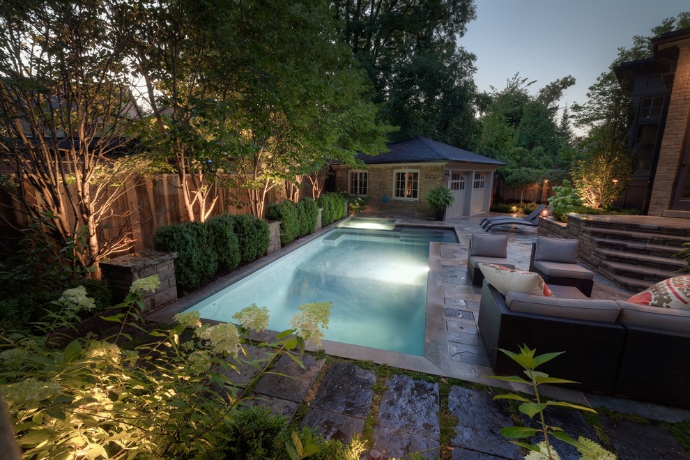 Ispirazione per una piccola piscina design rettangolare dietro casa con una vasca idromassaggio e pavimentazioni in pietra naturale