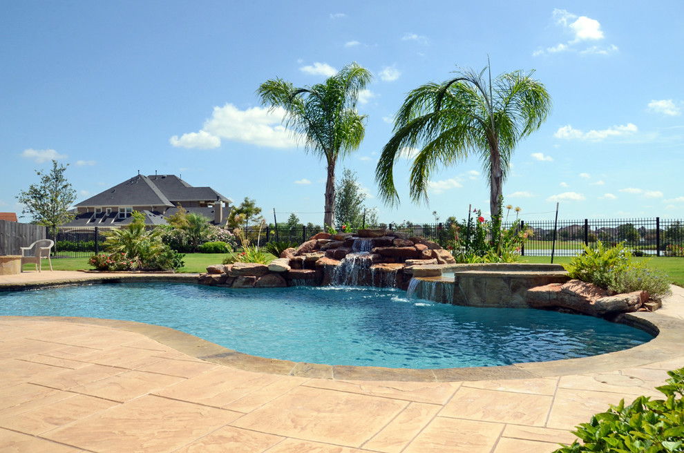 Idéer för att renovera en stor tropisk anpassad pool på baksidan av huset, med kakelplattor och en fontän