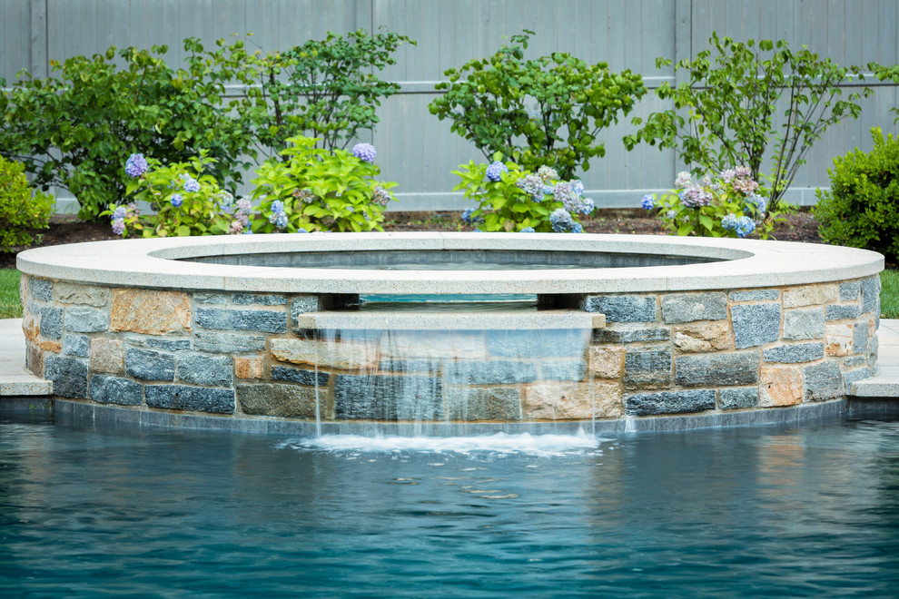 Idee per una grande piscina monocorsia tradizionale personalizzata dietro casa con pedane e una vasca idromassaggio