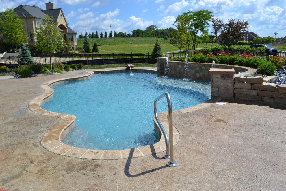 Bild på en stor funkis anpassad pool på baksidan av huset, med en fontän