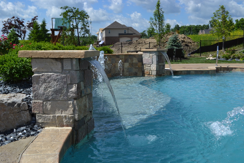 На фото: большой бассейн произвольной формы на заднем дворе в современном стиле с фонтаном