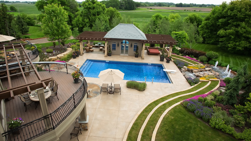 Ispirazione per un'ampia piscina tradizionale dietro casa con pavimentazioni in pietra naturale