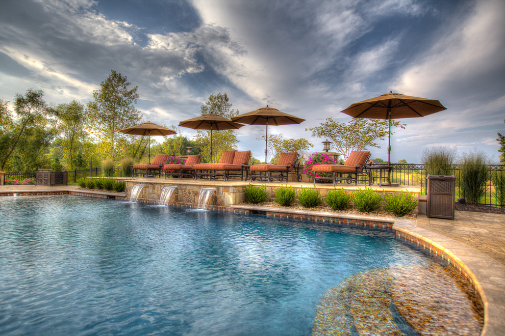 На фото: большой бассейн произвольной формы на заднем дворе в морском стиле с фонтаном и покрытием из каменной брусчатки с