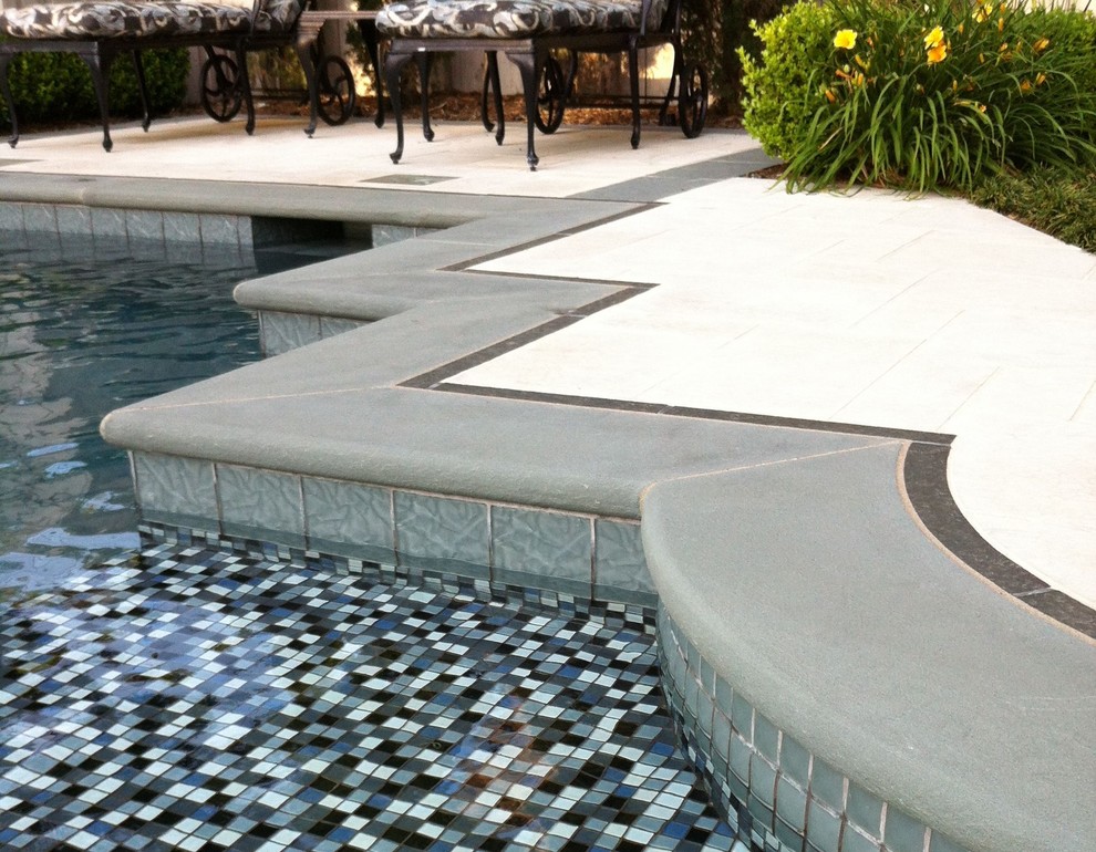 Imagen de piscinas y jacuzzis clásicos de tamaño medio a medida en patio trasero con adoquines de piedra natural