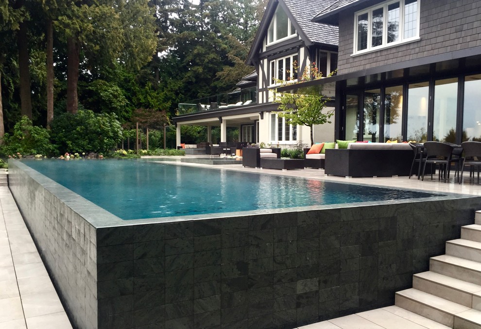 Foto de piscinas y jacuzzis infinitos modernos grandes rectangulares en patio trasero con suelo de baldosas