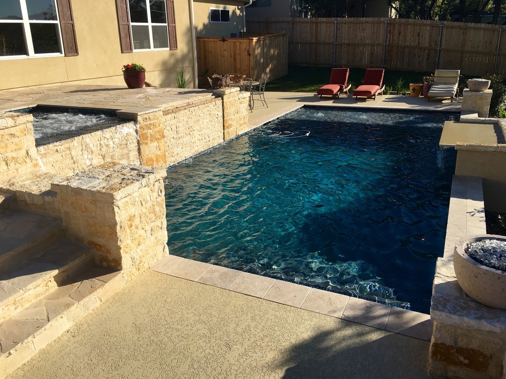 Example of a mid-sized tuscan backyard stone and rectangular natural pool fountain design in Austin