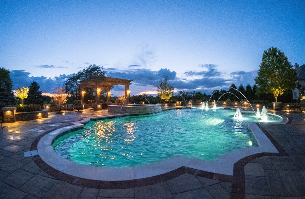 Immagine di una piscina monocorsia mediterranea personalizzata di medie dimensioni e dietro casa con una vasca idromassaggio e pavimentazioni in cemento