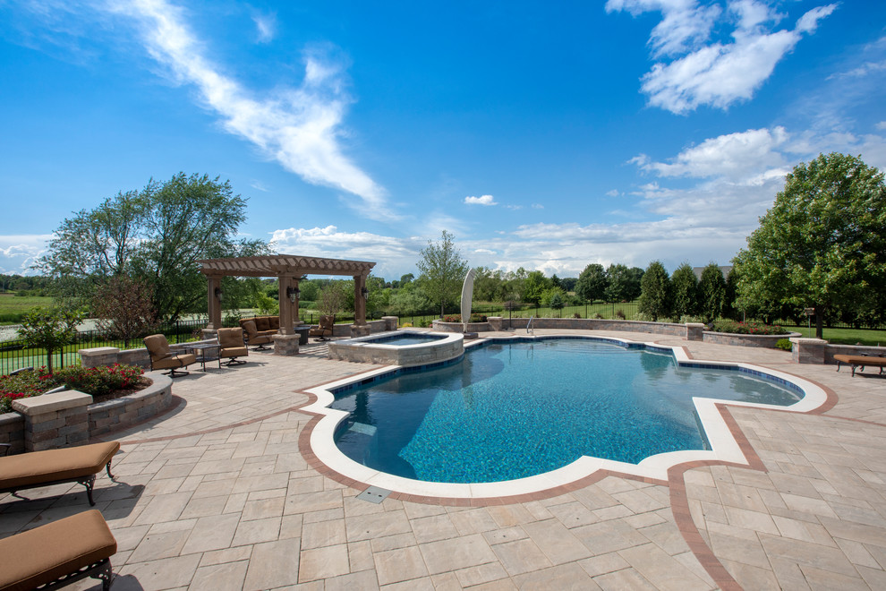 Immagine di una piscina monocorsia mediterranea personalizzata di medie dimensioni e dietro casa con una vasca idromassaggio e pavimentazioni in cemento