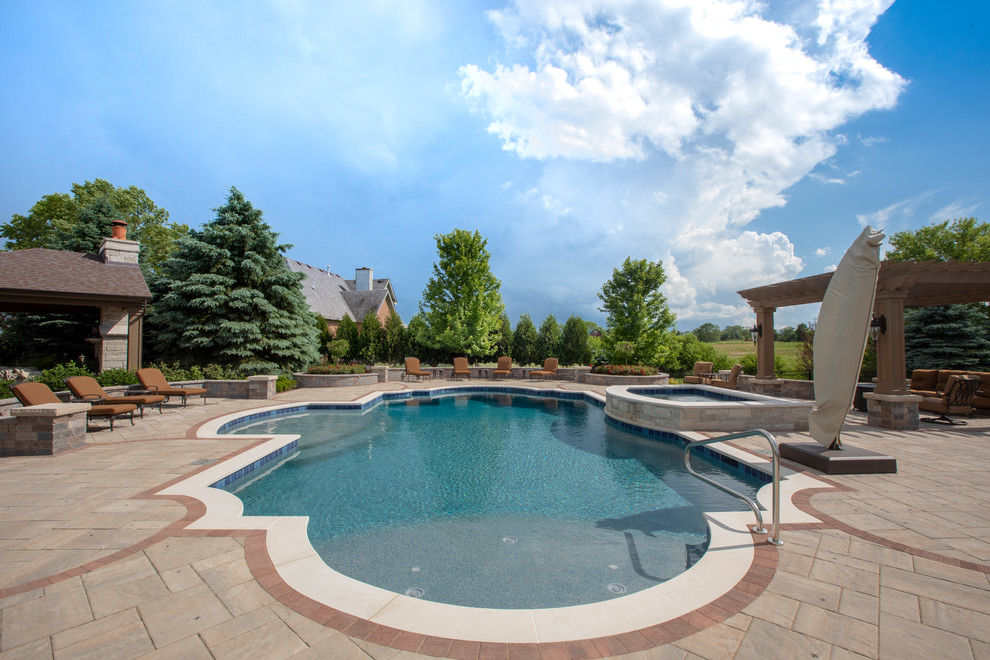This is an example of a medium sized mediterranean back custom shaped lengths hot tub in Chicago with concrete paving.
