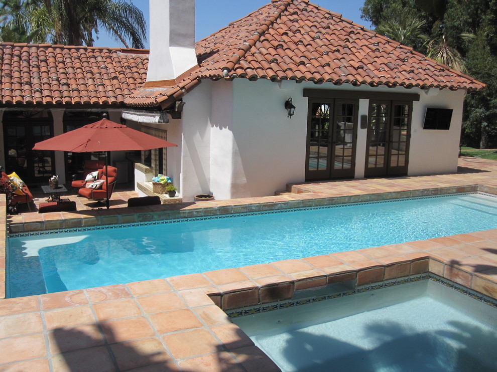 Immagine di una piscina monocorsia mediterranea rettangolare di medie dimensioni e dietro casa con piastrelle
