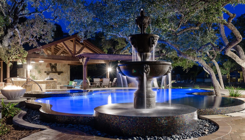 Large trendy backyard brick and custom-shaped infinity hot tub photo in Austin