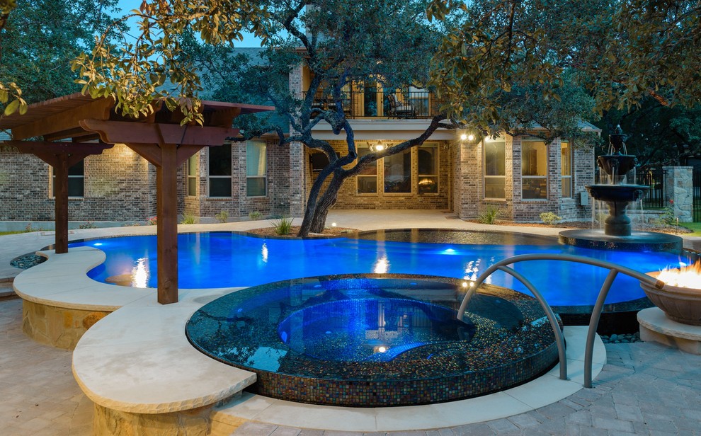 Foto de piscinas y jacuzzis infinitos contemporáneos grandes a medida en patio trasero con adoquines de ladrillo
