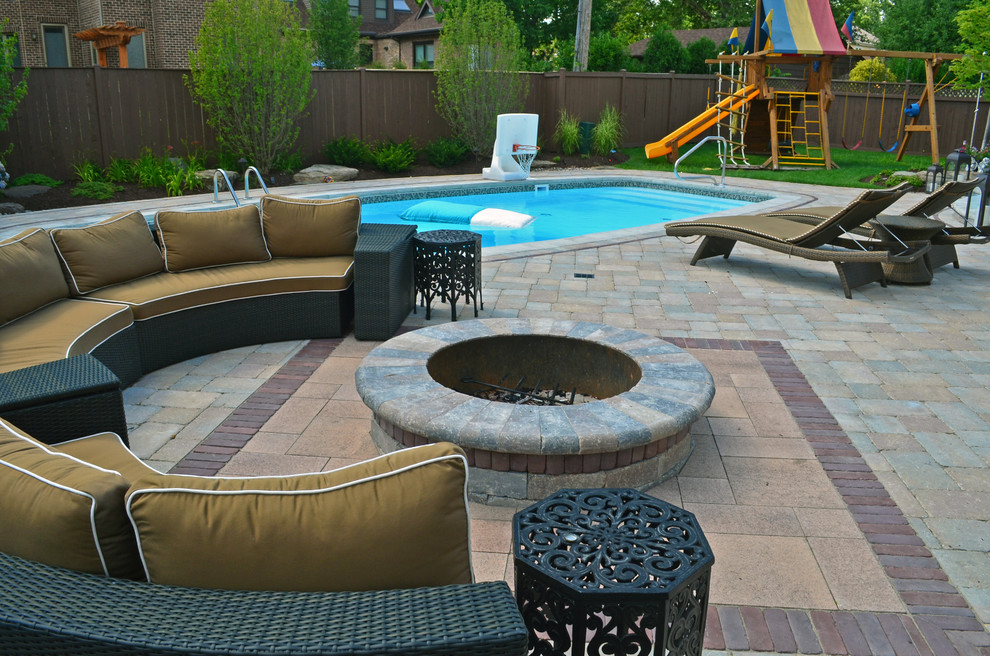 Large contemporary back rectangular swimming pool in Chicago with brick paving.