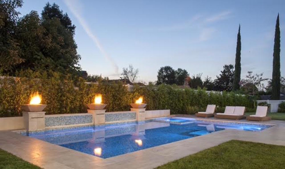 Imagen de piscinas y jacuzzis alargados retro de tamaño medio rectangulares en patio trasero con losas de hormigón
