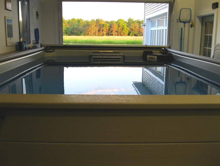Foto di un'ampia piscina coperta rustica rettangolare con una vasca idromassaggio e piastrelle