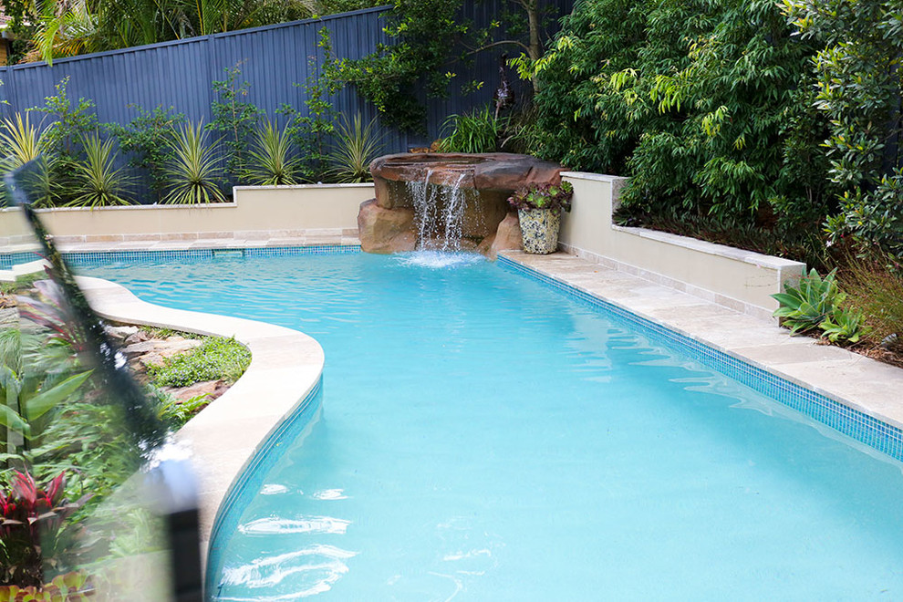 Foto de piscina contemporánea de tamaño medio a medida en patio trasero con adoquines de piedra natural