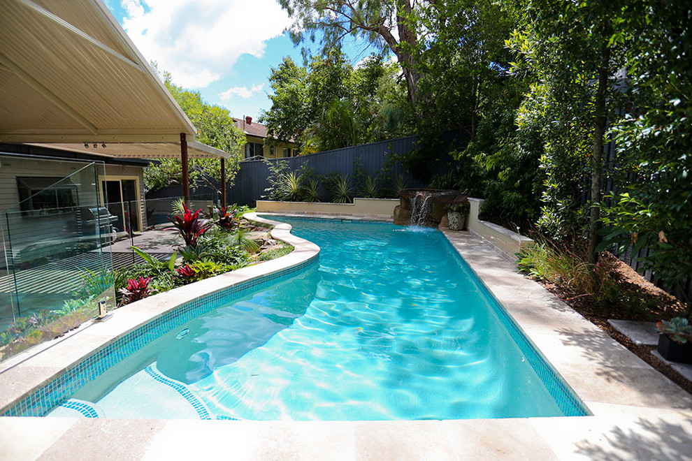 Cette photo montre une piscine arrière tendance de taille moyenne et sur mesure avec des pavés en pierre naturelle.