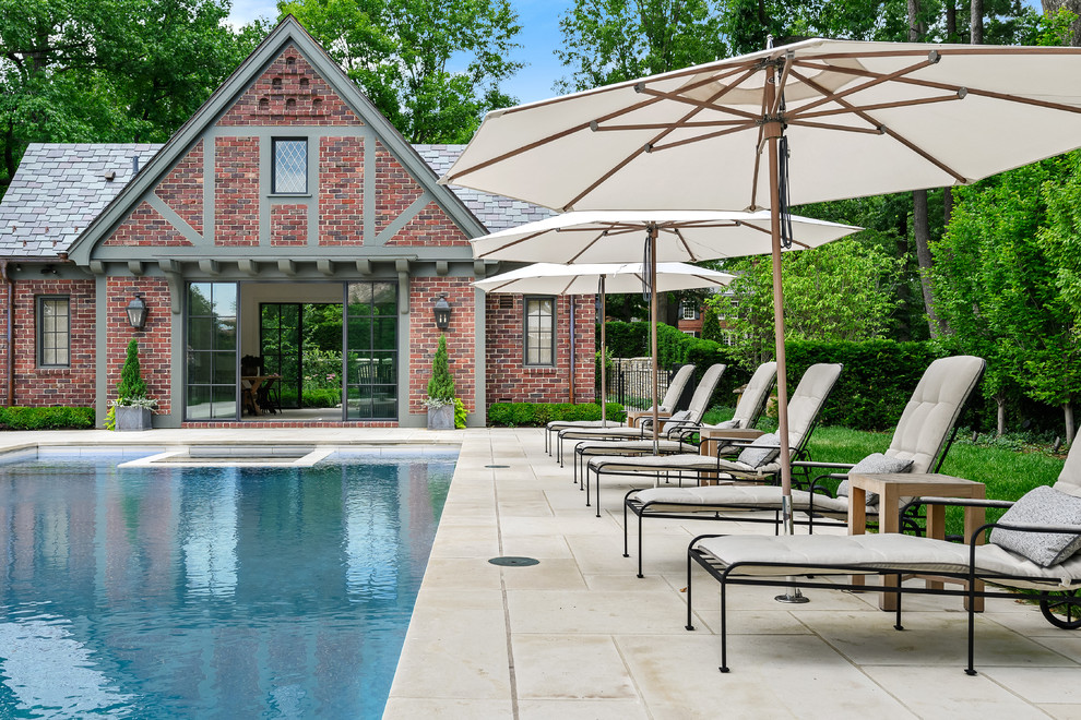 Стильный дизайн: большой естественный, прямоугольный бассейн на заднем дворе в классическом стиле с домиком у бассейна и покрытием из декоративного бетона - последний тренд