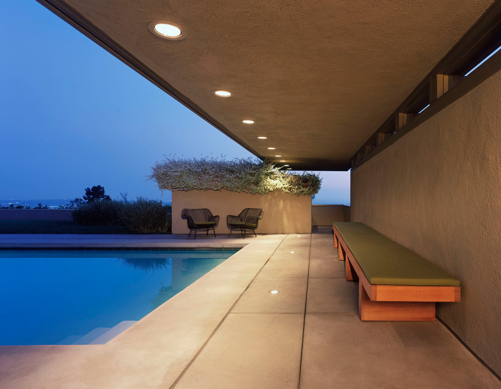 Стильный дизайн: прямоугольный бассейн в стиле модернизм с покрытием из бетонных плит - последний тренд