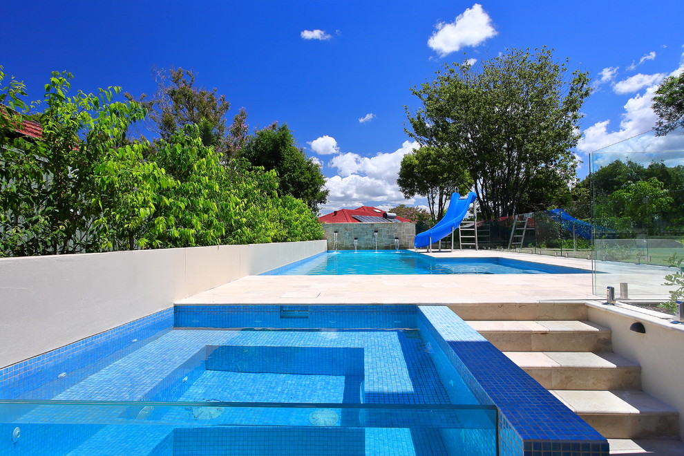 Идея дизайна: большой угловой бассейн на заднем дворе в современном стиле с джакузи