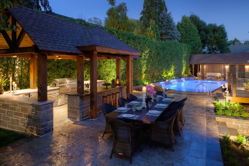 Diseño de casa de la piscina y piscina alargada contemporánea grande rectangular en patio trasero con suelo de hormigón estampado