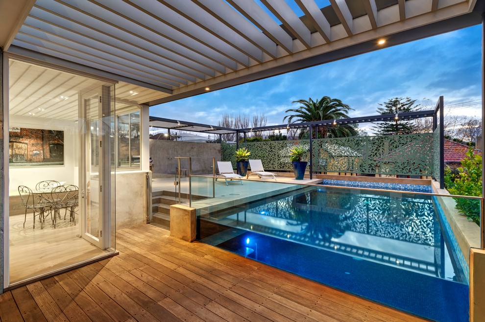 Foto de piscina con fuente contemporánea grande en patio trasero con entablado