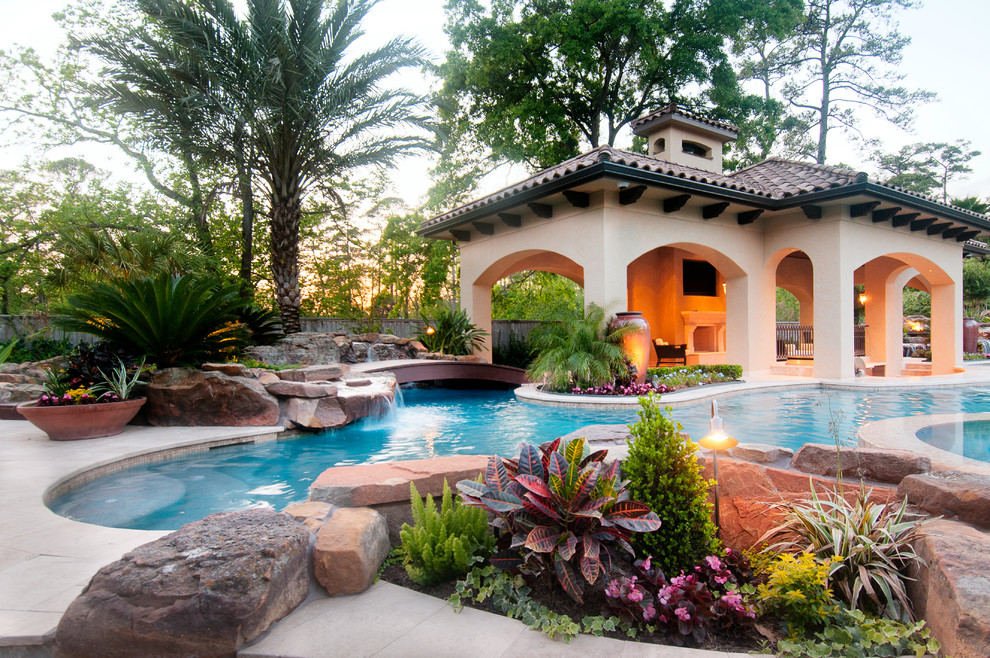 Esempio di un'ampia piscina monocorsia mediterranea personalizzata dietro casa con una vasca idromassaggio e piastrelle