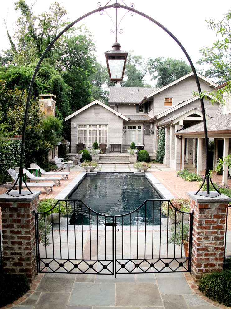 Imagen de piscina clásica de tamaño medio rectangular en patio lateral con adoquines de ladrillo