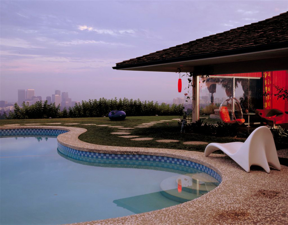 Diseño de piscina tradicional de tamaño medio tipo riñón en patio trasero con granito descompuesto
