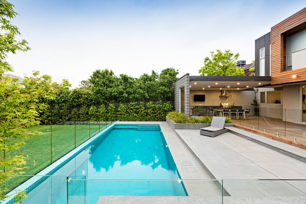 Modelo de piscina con fuente contemporánea grande en patio trasero