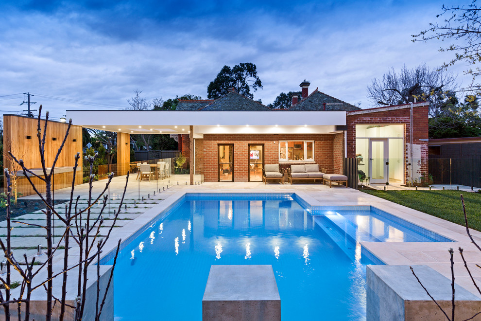 Foto di una grande piscina contemporanea rettangolare dietro casa con paesaggistica bordo piscina e pavimentazioni in pietra naturale
