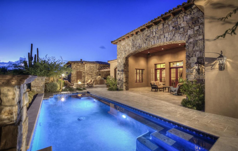 Diseño de piscina con fuente alargada tradicional extra grande rectangular en patio con adoquines de piedra natural
