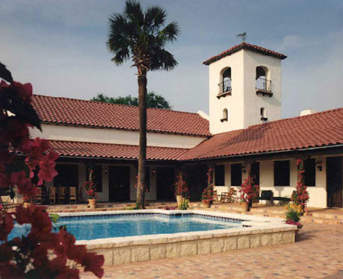 Example of a huge tuscan courtyard rectangular and brick lap pool design in Houston
